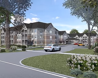 Exterior view of a multi-story senior living facility with a driveway, parked cars, trees, and landscaped greenery under a partly cloudy sky.