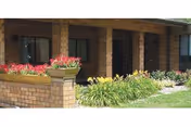 Brick exterior of Lakeside Health & Rehab Center with flower planters at the entrance.