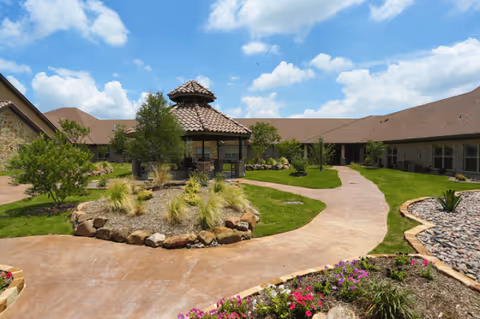 Exterior view of Belterra Health & Rehabilitation Center courtyard with a stone pavilion and pathways