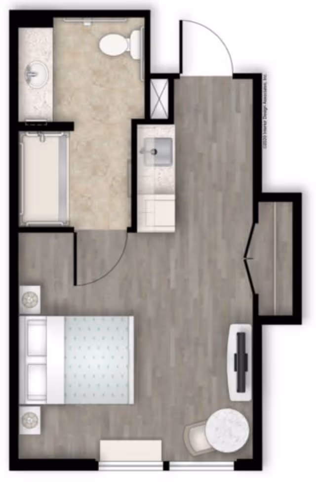 Floor plan of a small apartment unit showing a bedroom with a bed and two nightstands, a bathroom with a toilet, sink, and bathtub, and a small kitchenette area with a sink. There is also a small round table with a chair and a TV opposite the bed.