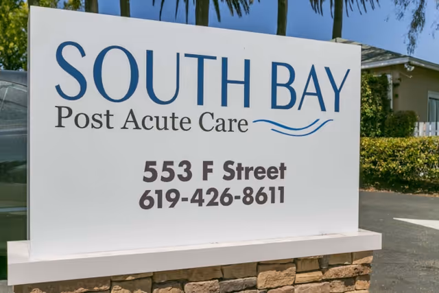 A freestanding outdoor sign for South Bay Post Acute Care displaying the address '553 F Street' and a phone number.