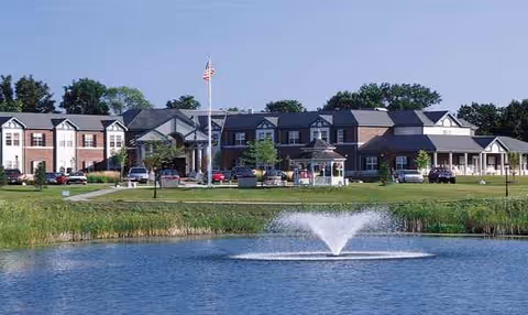 Exterior view of ProHealth Regency Senior Communities Muskego facility with pond, fountain, and manicured lawn.