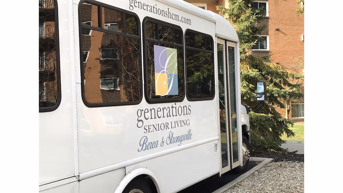 White shuttle bus parked outside a senior living facility with the logo and text 'generations SENIOR LIVING Berea & Strongsville' on its side, along with the website generationshcm.com. The background shows part of a brick building and some greenery.