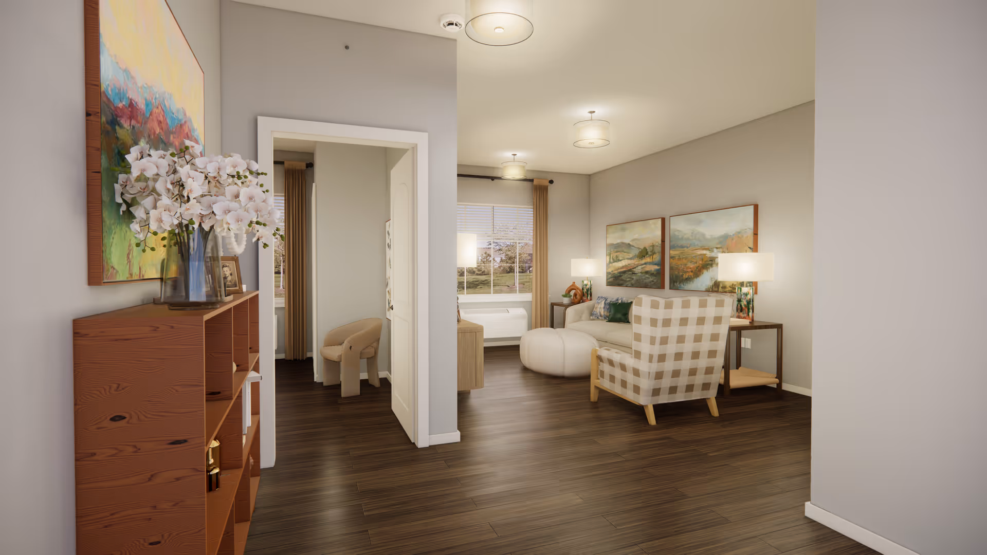 Bright senior living apartment interior showing a hallway with a wooden shelf and flowers leading to a cozy living area with armchairs, an ottoman, side tables, and wall art.