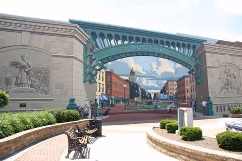 Exterior view of Altercare Bucyrus entrance with green arch and benches.