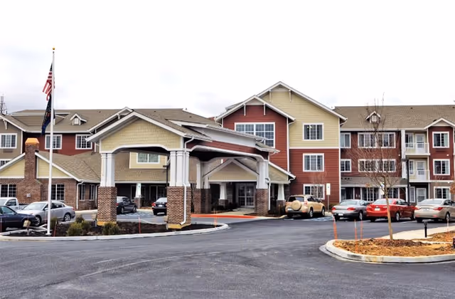Exterior view of Sterling Heights Gracious Retirement Living with a covered entrance and parked cars.