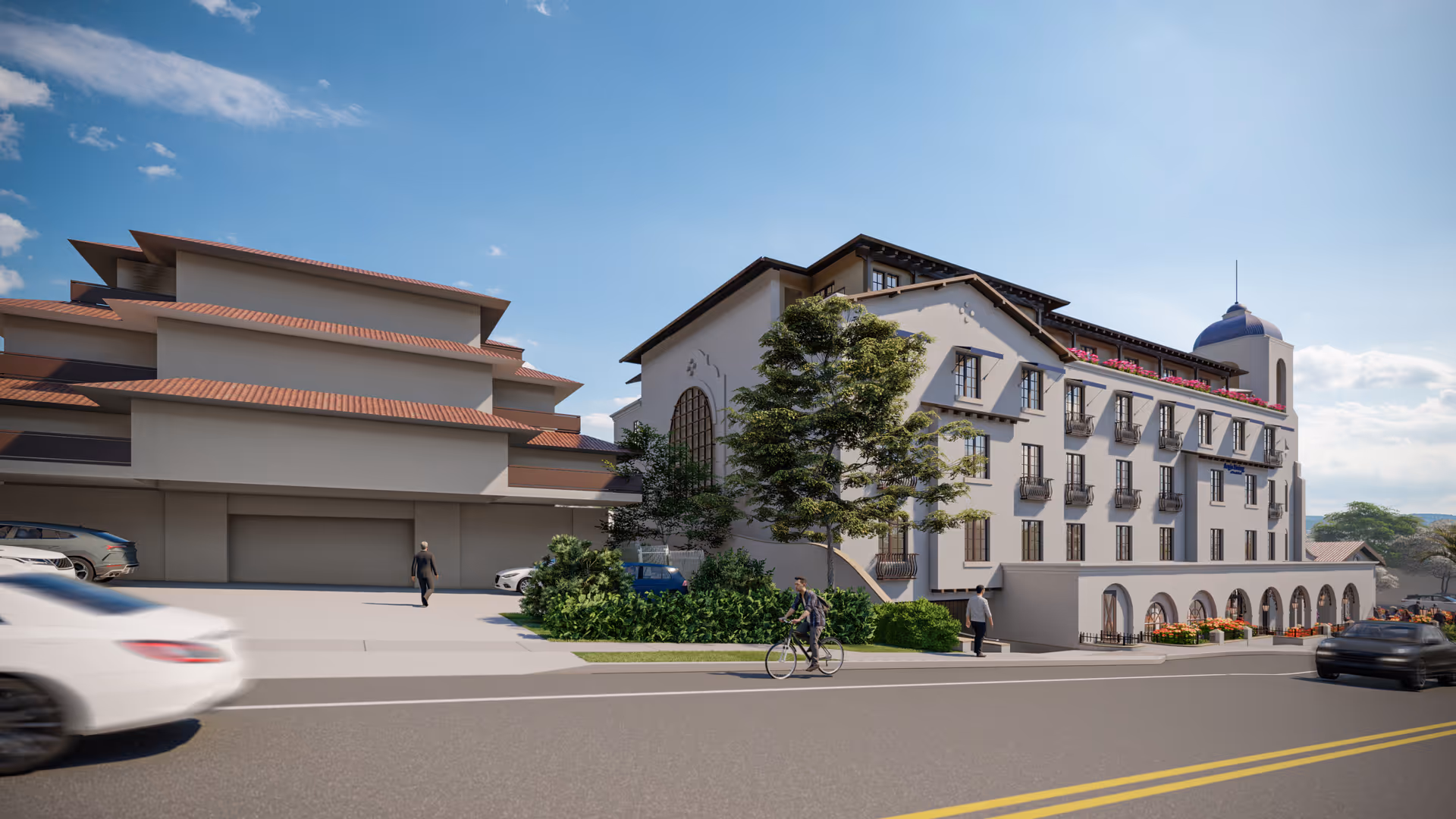 Front exterior of a multi-story Mediterranean-style senior living building with arched windows, balconies, trees, parked cars and people along the street.