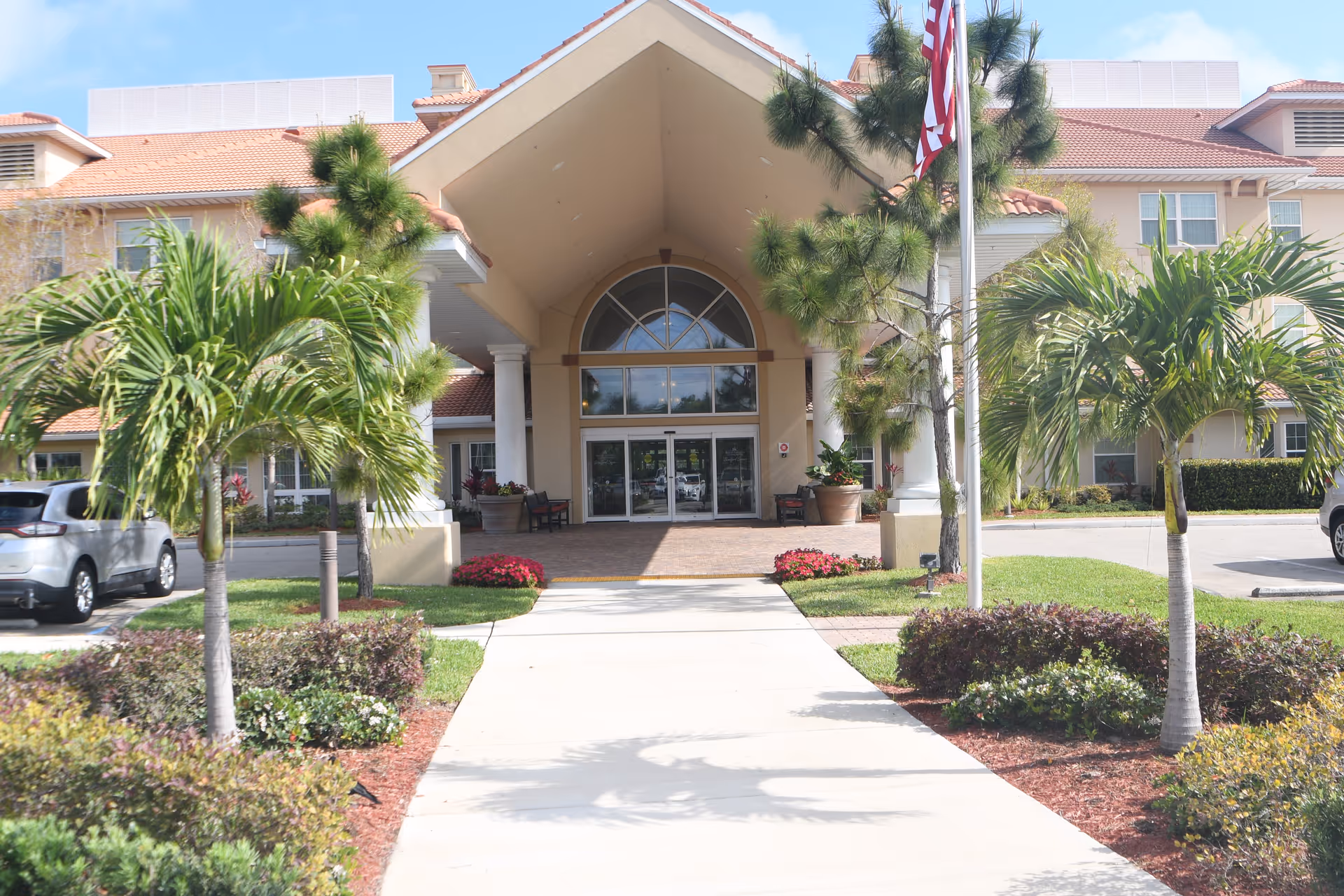 Bradford Square Retirement Community building front with palm trees and glass entrance.