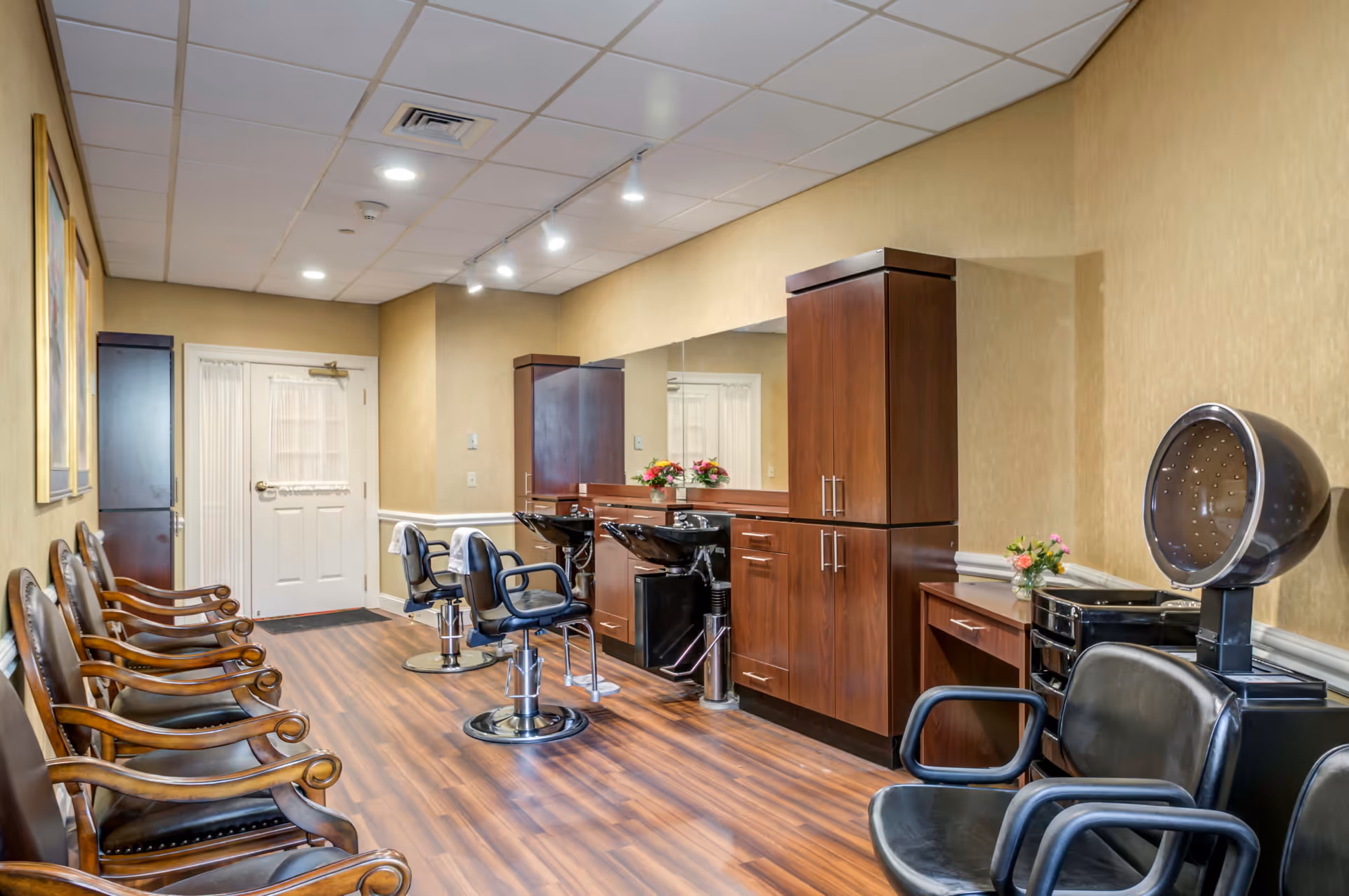 Interior hair salon with styling chairs, shampoo stations, waiting chairs, and wooden cabinetry.
