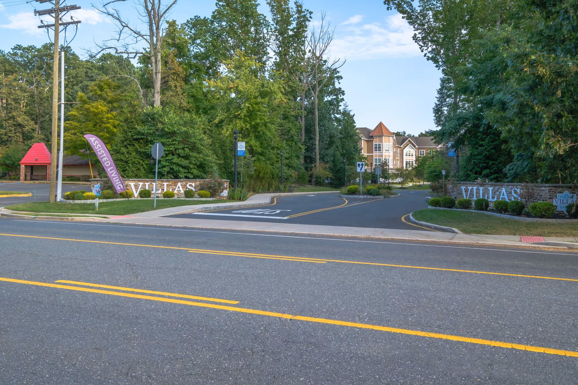Entrance driveway and signage for The Villas senior living community with landscaped grounds and the facility building visible in the background.