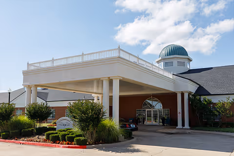 Front entrance of Arbor House of Norman senior living facility featuring a covered drive.