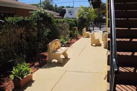 Outdoor walkway in a courtyard with benches, planters, and stairs.
