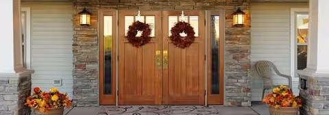 Front entrance of Heritage Senior Living at Oakwood Hills with wreaths, lanterns, and autumn planters.