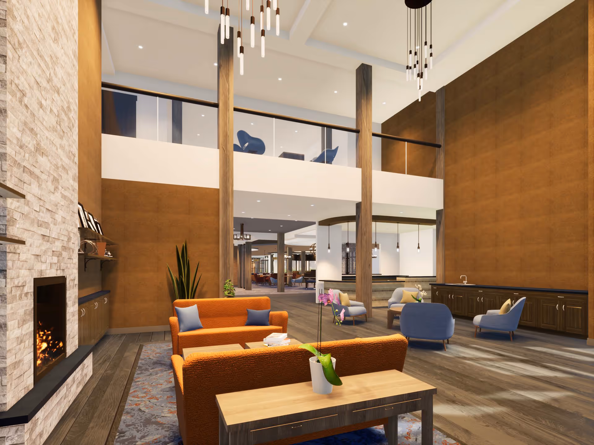 Spacious and modern senior living facility common area with high ceilings, large windows, and warm lighting. The room features orange sofas with blue pillows, a wooden coffee table with a potted orchid, a stone fireplace on the left, and several blue armchairs. There is a second-floor balcony with glass railing and additional seating. The floor is wooden, and the walls are a warm brown color. Pendant lights hang from the ceiling, adding to the cozy ambiance.