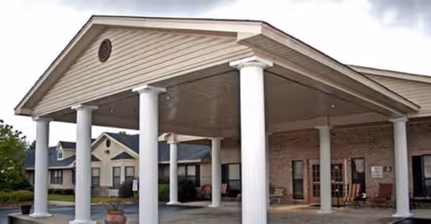 Exterior view of CaraVita Village entrance with a covered portico and white columns.