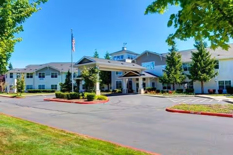Exterior view of Arbor Ridge senior living facility with entrance, parking lot, and landscaping.