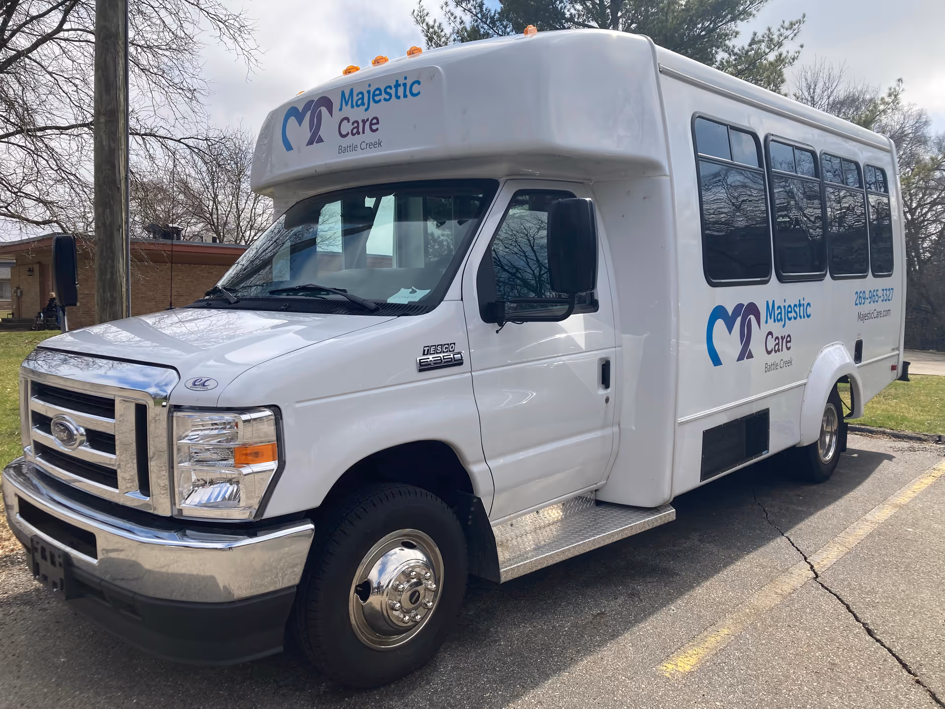White shuttle bus parked in a lot with 'Majestic Care Battle Creek' logo on the side and front.