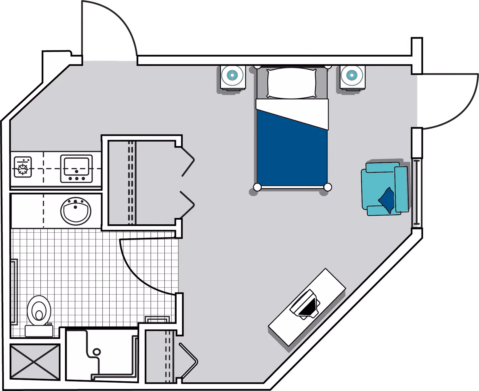 Floor plan of a senior living facility room at Oaks at Tucker showing a bedroom with a bed, two nightstands, an armchair, and a desk. The room also includes a bathroom with a toilet, sink, and shower, as well as a small kitchenette area with a stove and sink.