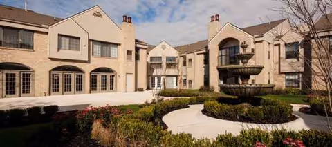 A large senior living campus with a central fountain and landscaped courtyard.