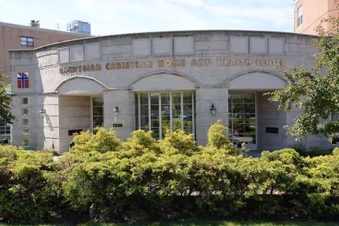 Front view of Norwegian Christian Home and Health Care Center entrance with shrubs