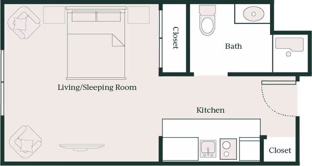 Floor plan of a senior living studio apartment at Emerald City at Greenlake Senior Living, showing a combined living and sleeping room with a bed, two chairs, and a TV, a kitchen area with appliances and a sink, a bathroom with a toilet, sink, and bathtub, and two closets.