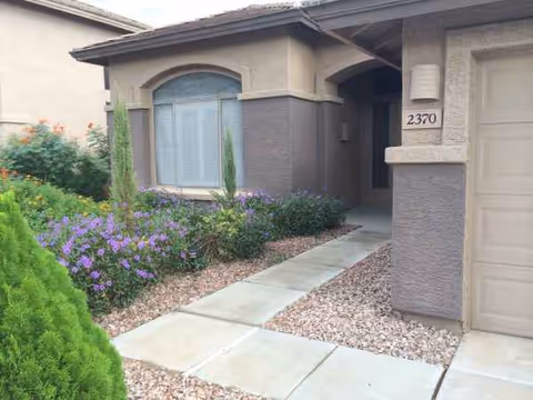 Front entrance of a residential senior living building with landscaped walkway