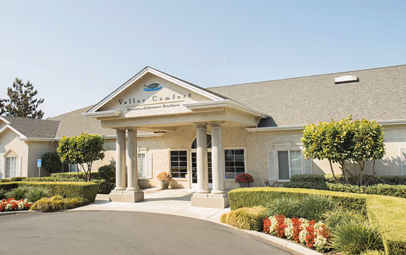 Exterior view of Valley Comfort facility with a covered entrance and landscaped front yard.