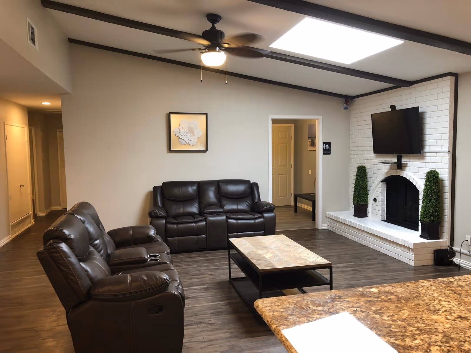 Spacious living room with leather recliners, a fireplace, and a wall-mounted TV.