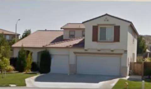 Exterior view of a two-story suburban care facility with a double garage.