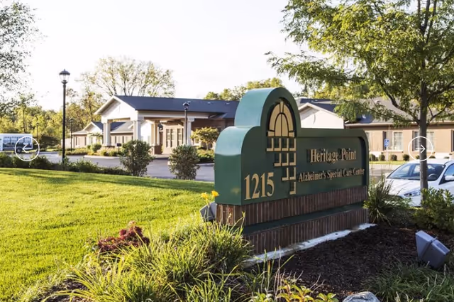 Exterior view of Heritage Point Alzheimer's Special Care Center with front sign and manicured landscaping