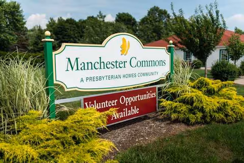 Manchester Commons exterior sign with landscaped grounds and volunteer opportunities.