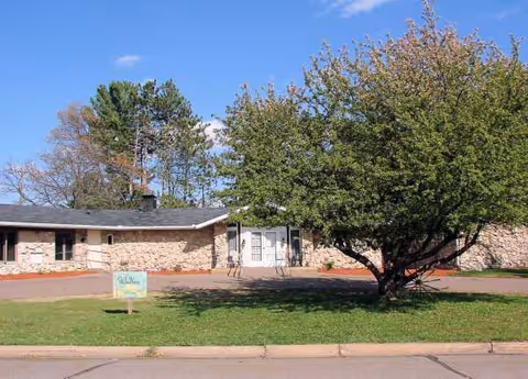 Exterior view of Willow Haven CBRF with a tree, lawn, and entrance.