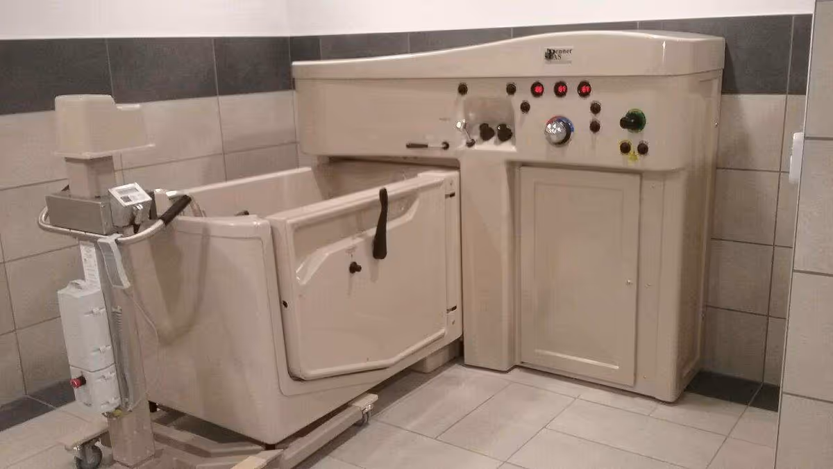 A bathtub lift device installed in a tiled bathroom.