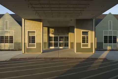 Front entrance of Borgess Gardens facility with a covered porte-cochere and glass doors.