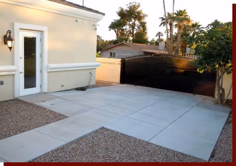 Sunlit exterior of a senior living facility with a gated driveway and entrance.