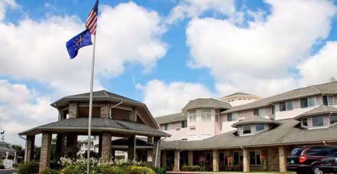 Exterior view of Arbor Glen Independent and Assisted Living entrance with flagpole.