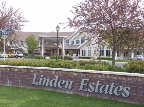 A brick Linden Estates sign in front of a senior living facility exterior.