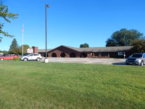 A single-story brick care center exterior with arched entrances and a front parking lot.