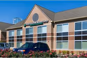Fraser Villa senior living building exterior with parked cars and landscaped foreground.