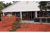 Front entrance of Suwannee Valley Nursing Center with a wooden sign, brick building, and red-mulched landscaping.