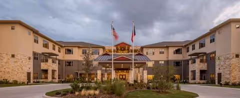 Front exterior of Village on the Park Plano with entrance doors and flagpoles