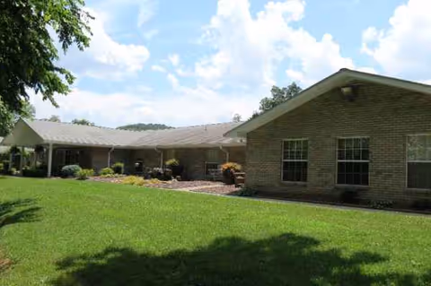 Brick building of Hillview Health and Rehabilitation Center with a green lawn and covered entrance.