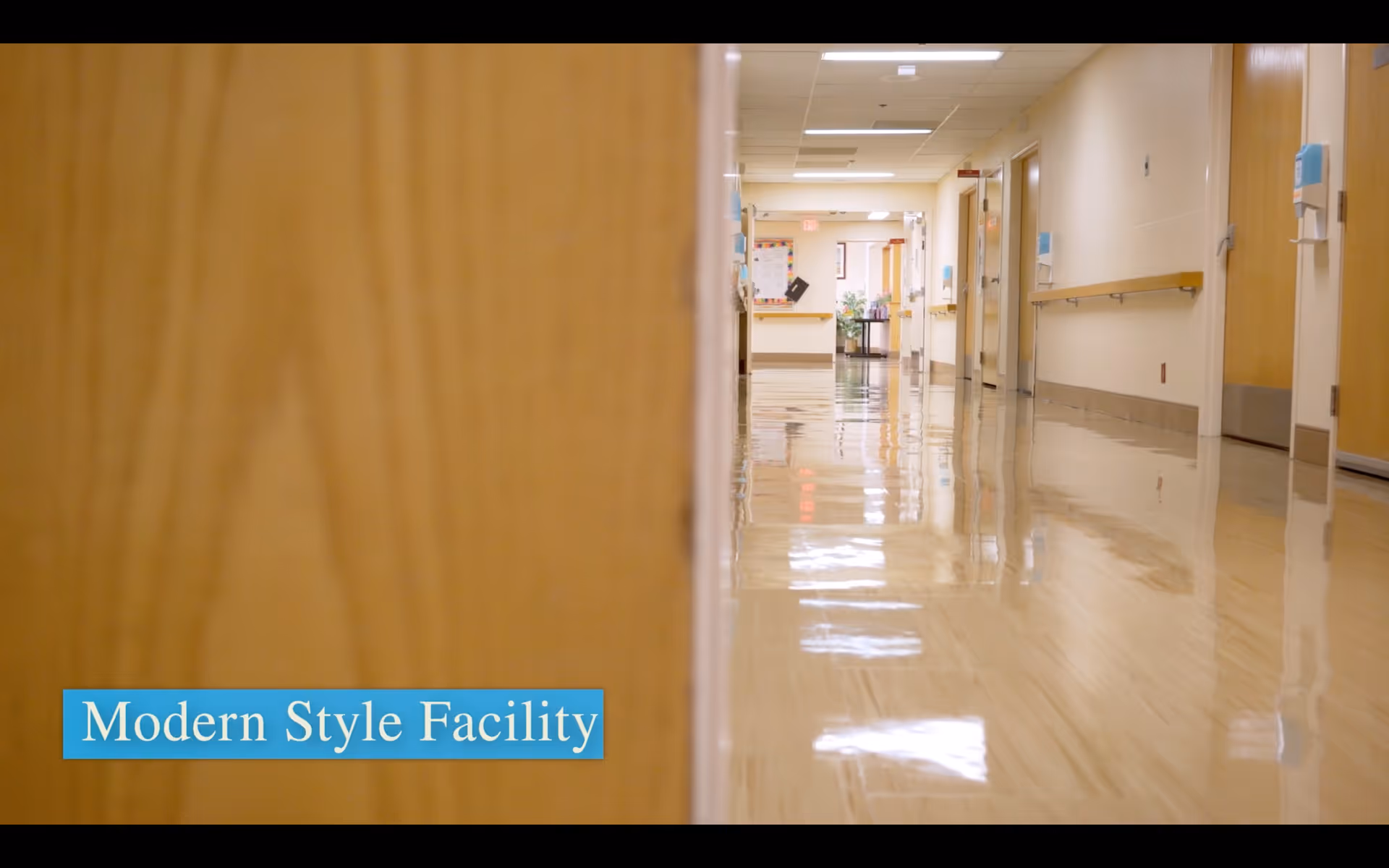 Polished healthcare hallway with wooden doors and handrails reflecting on a shiny floor, labeled "Modern Style Facility" in the bottom-left.