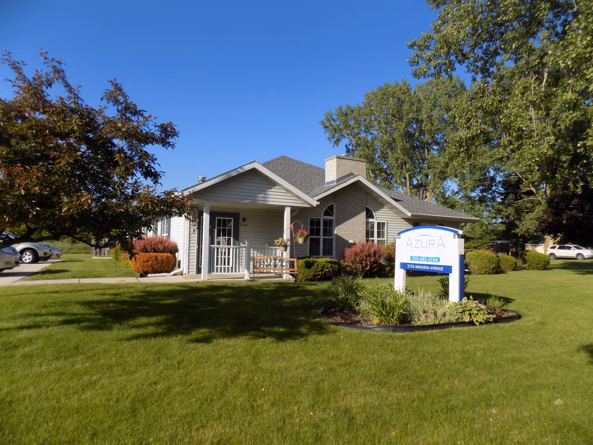 Front exterior of a single-story house-style care building with a manicured lawn and an Azura sign near the entrance.