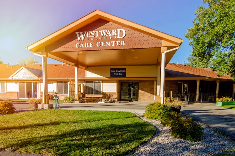 Entrance of Westward Heights Care Center showing a covered porte-cochère with signage, benches, and a front lawn.