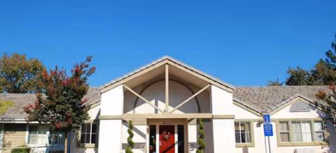 Front exterior view of Brookdale Danville senior living facility with red entry door and manicured landscaping