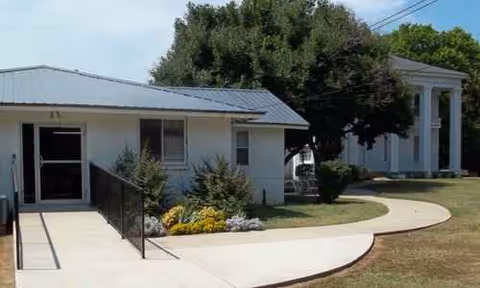 Exterior view of Colonial Haven Care and Rehabilitation Center with walkway and landscaping.