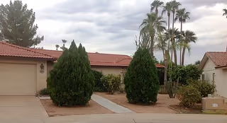 Front exterior of a single-story building with a red-tiled roof and desert landscaping.
