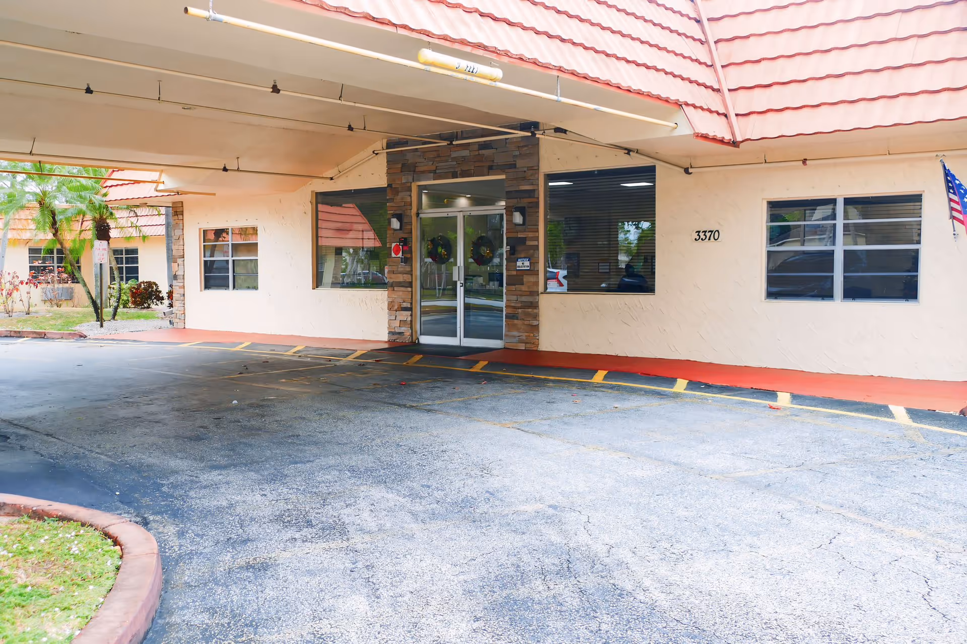 Front entrance of Palms Care Center with a covered drive-through, glass double doors, and the address number 3370 visible on the facade.