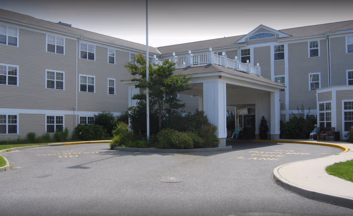 Exterior view of Wellington Estates assisted living facility with entrance canopy and circular drive